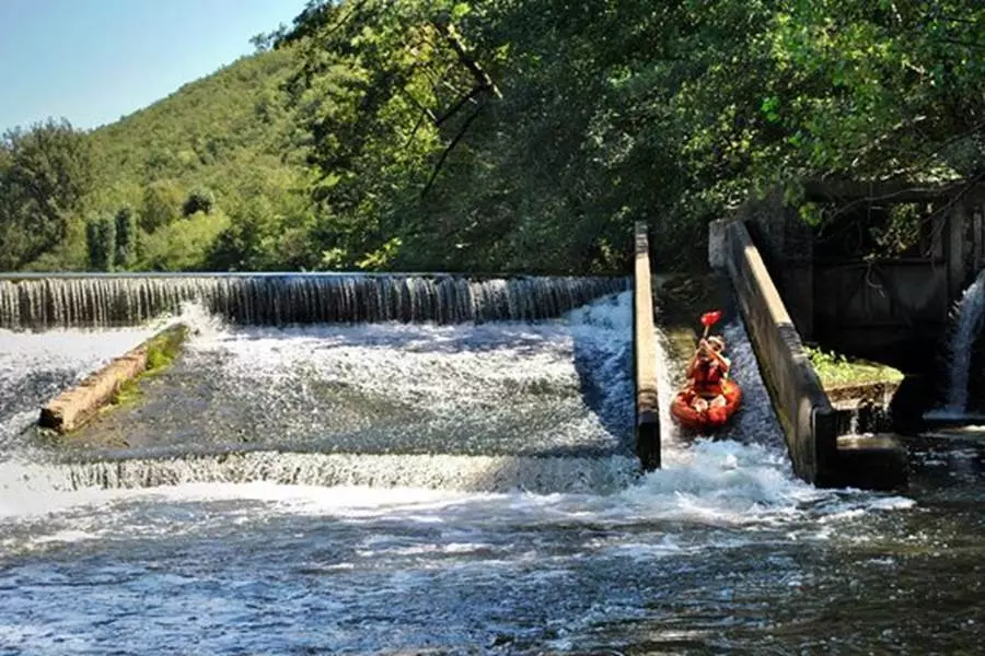 un kayak dévale un chute d'eau dans la rivière aveyron, à proximité de saint antonin noble val ;les kayakistes ont levé leurs rames et se laissent porter par les flots