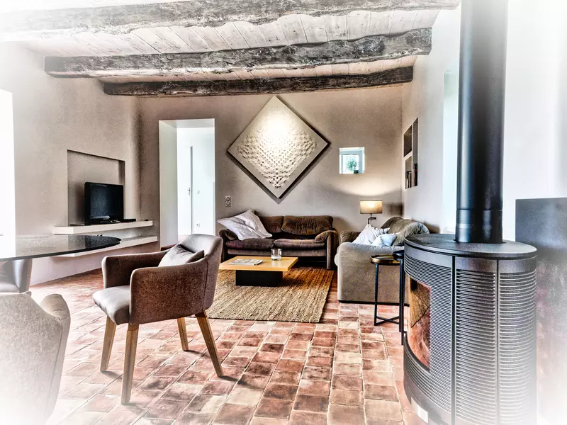 photo de la pièce à vivre, salon et salle à manger, du gite la cubane dans le quercy-rouergue en occitanie ; l'image est travaillée dans des teintes sépia et un fort contraste de l'ensemble, donnant l'impression qu'il s'agit d'une peinture