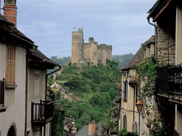 la rue de najac, village de l'aveyron en occitanie, étroite, bordée de maison qui descend en suivant la crête d'un promontoire, puis remonte vers le fond pour s'élever vers le château qui domine