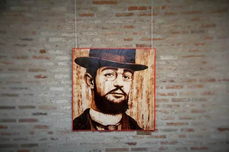 autoportrait de henri de toulouse-lautrec ; le tableau est accroché devant un mur en brique