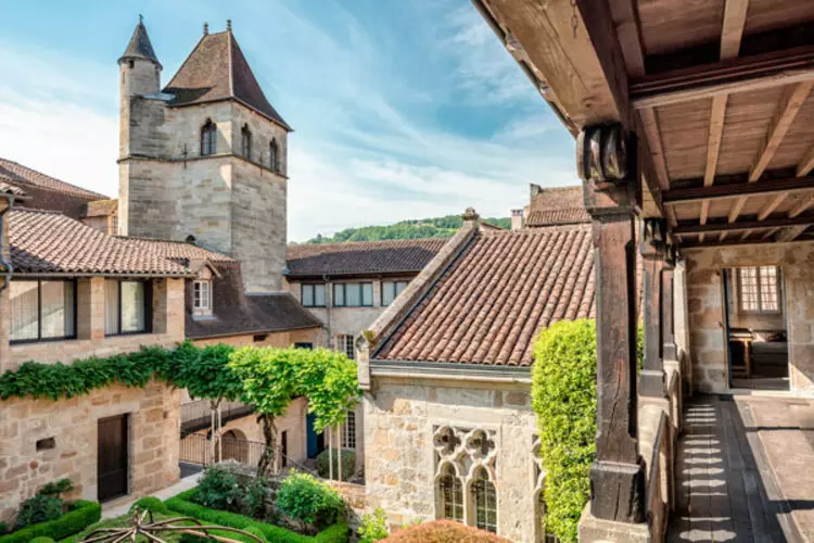 vue du cloître de l'abbatiale de figeac dans le lot, région occitanie. depuis la coursive d'où est prise la photo, on voit le jardin du cloître et le clocher de l'église
